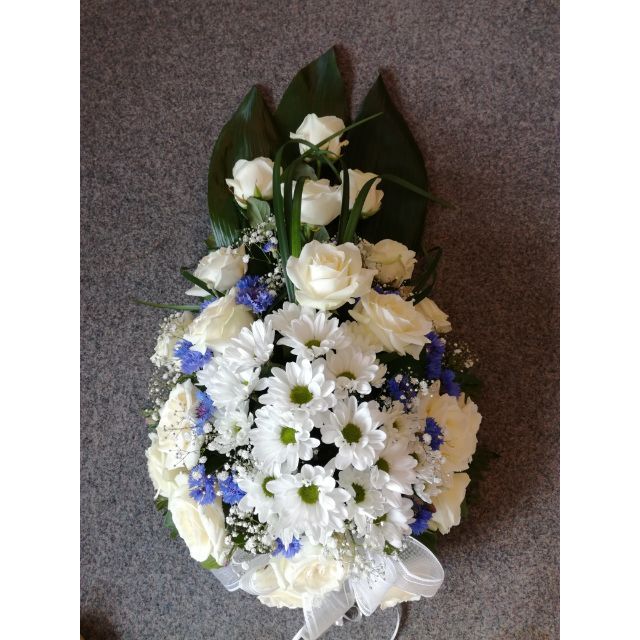 Sinisistä ja valkoisista kukist asidottu hautajaisvihko